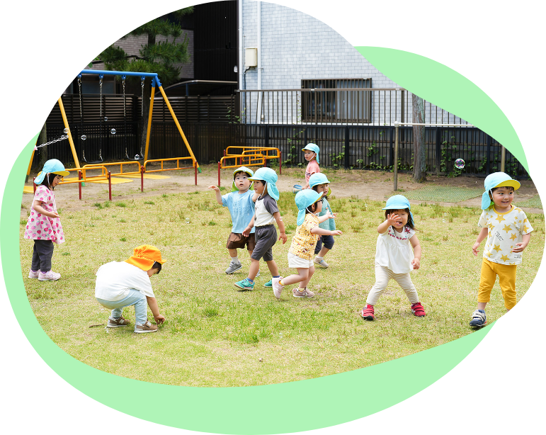 園庭で野菜に水をやる園児