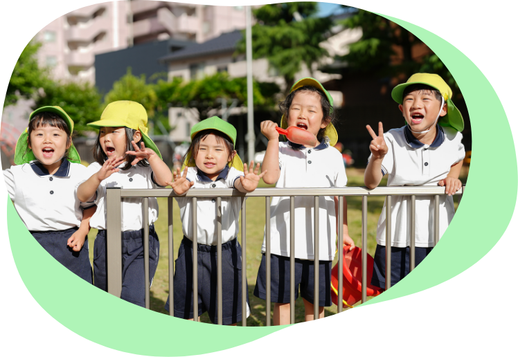 園庭で笑顔を見せる園児